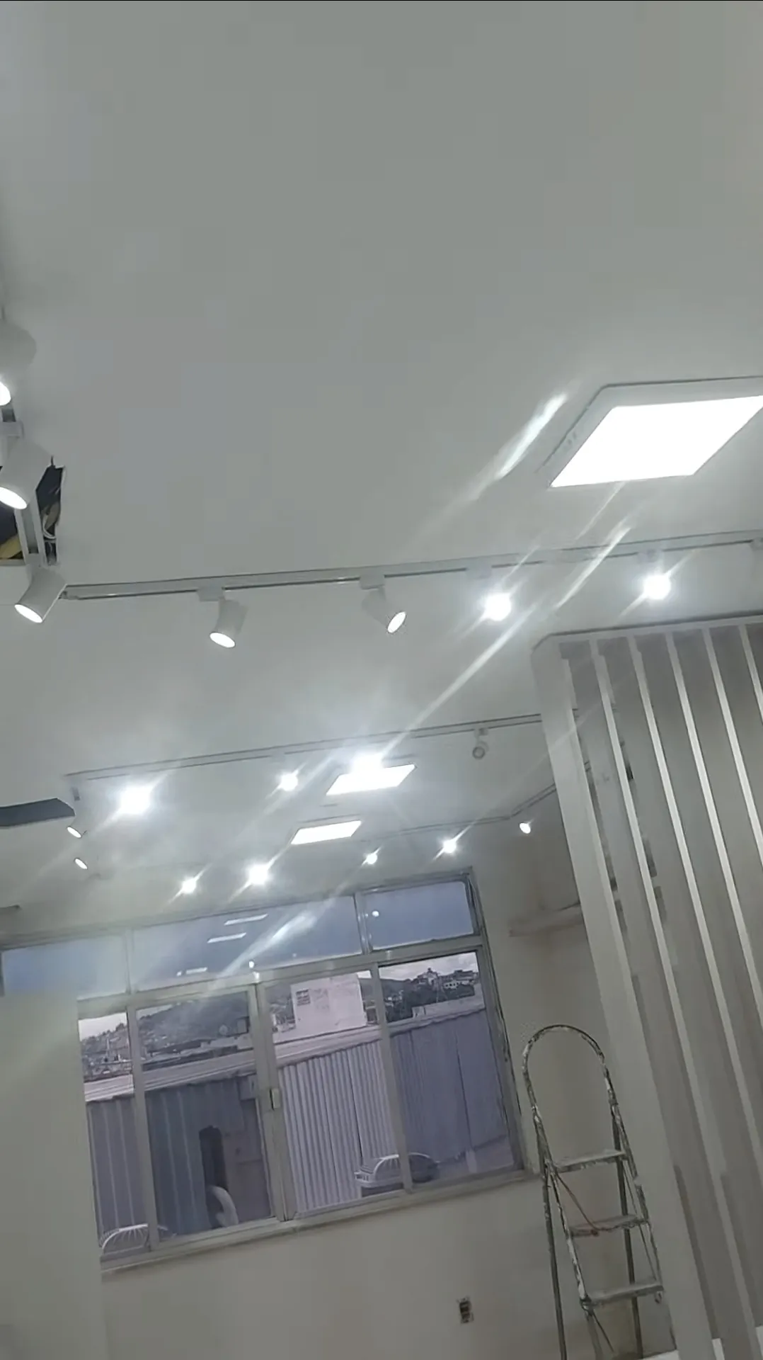 Ambiente comercial com trilhos, spots e painéis de iluminação instalados