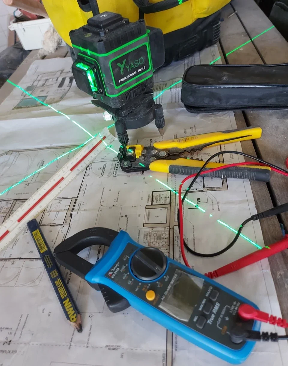 Ferramentas e instrumentos sobre planta para planejamento elétrico comercial.