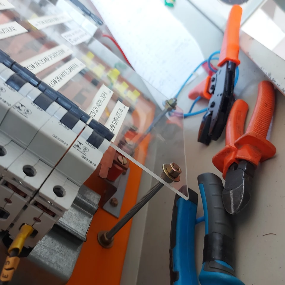 Quadro elétrico comercial em montagem com disjuntores e ferramentas de trabalho.