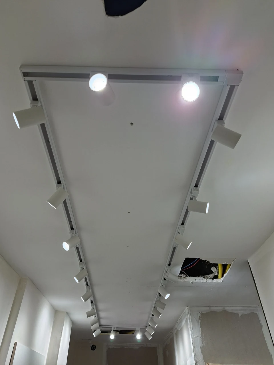 Trilhos de iluminação instalados no teto de ambiente comercial.