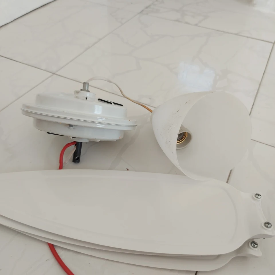 Ventilador de teto e luminária desmontados para manutenção residencial.